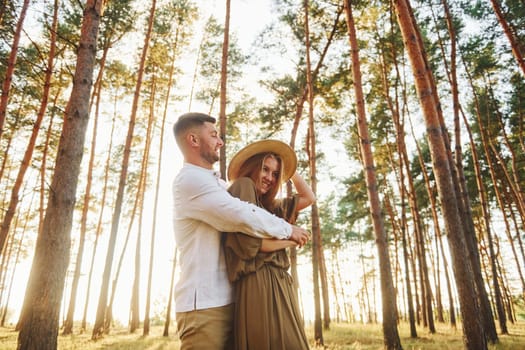 Weekend time spending. Happy couple is outdoors in the forest at daytime.