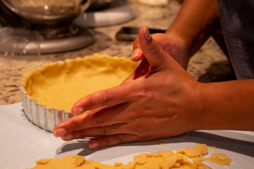Preparing the perfect cake: Close-up of hands shaping the dough for a homemade cake. High quality photo