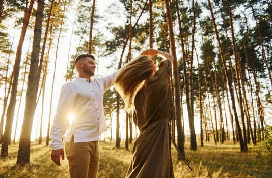 In the forest at daytime. Happy couple is outdoors.