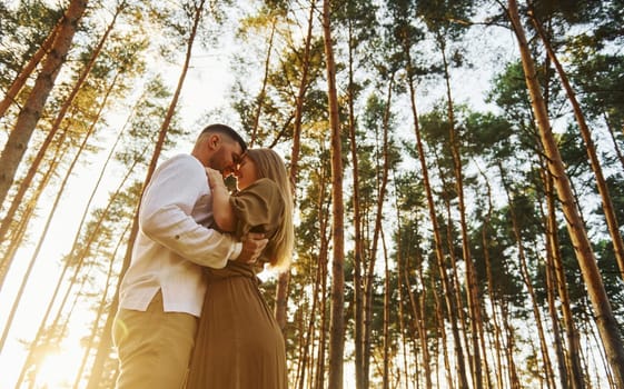 In the forest at daytime. Happy couple is outdoors.