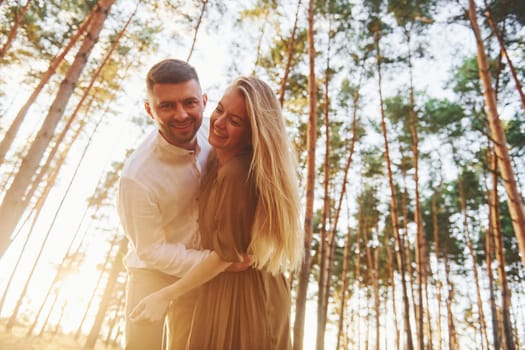 In the forest at daytime. Happy couple is outdoors.