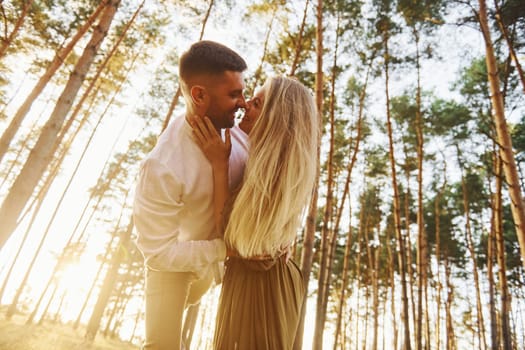 In the forest at daytime. Happy couple is outdoors.