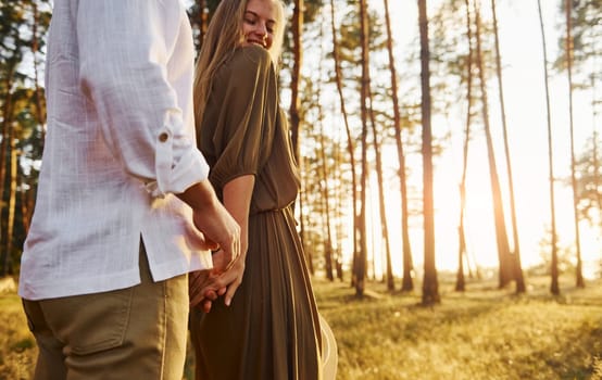 Tenderness and hapiness. Couple is outdoors in the forest at daytime.