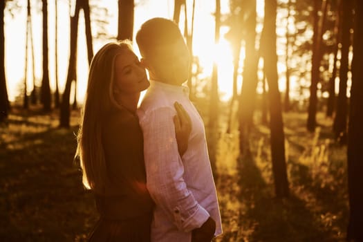 Tenderness and hapiness. Couple is outdoors in the forest at daytime.