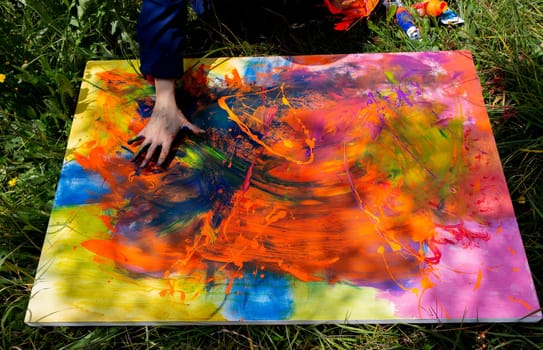 Bringing Color to Life: Hands of a painter putting the finishing touches on a vivid abstract painting. High quality photo
