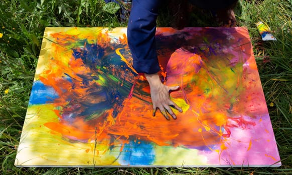 The art of colour, Close-up of the hands of a painter adding the finishing touches to a vibrant abstract painting. High quality photo