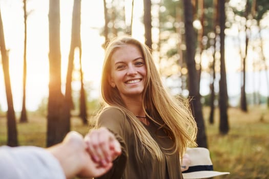 Happy couple is outdoors in the forest at daytime.