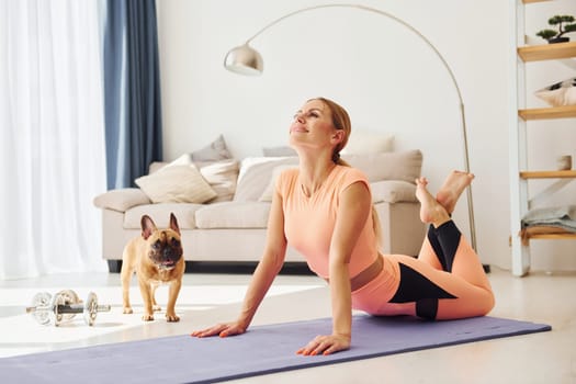 Woman with pug dog is at home at daytime.