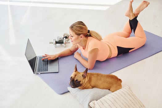 Woman with pug dog is at home at daytime.