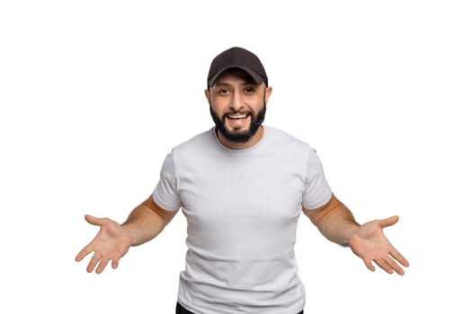 Portrait of young middle eastern bearded man with white t-shirt and cap looking at camera.