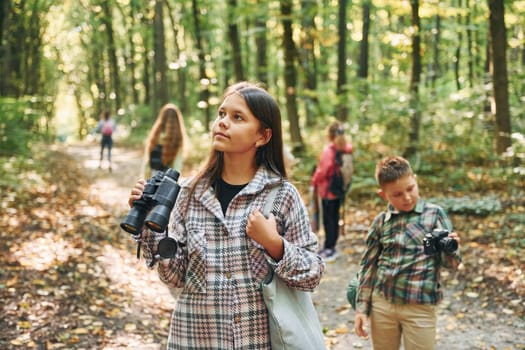 Discovering new places. Kids in green forest at summer daytime together.