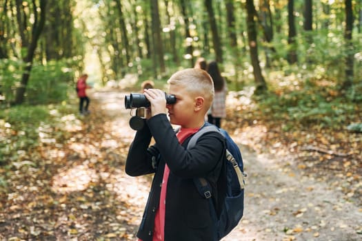 Discovering new places. Kids in green forest at summer daytime together.