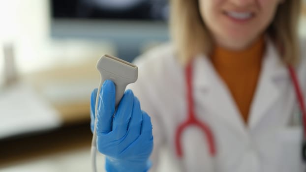 Ultrasonic machine sensor in hands of doctor therapist in clinic closeup. Ultrasound examination of internal organs concept