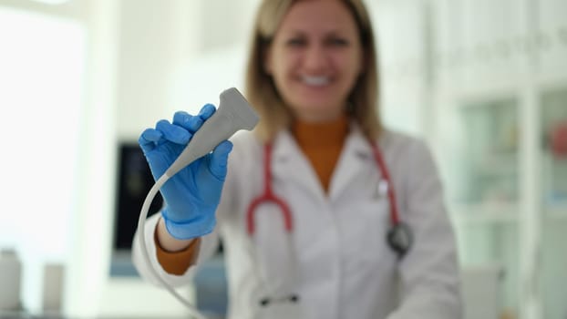 Doctor of ultrasound diagnostics holding probe in hands in clinic closeup. Instrumental diagnostics of diseases of internal organs concept