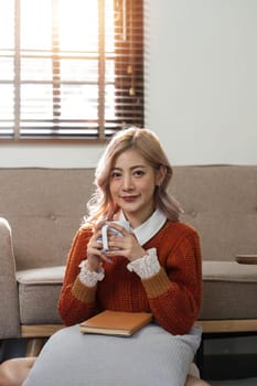 cheerful beautiful pretty asian woman smiling happy relaxing drinking of hot coffee or tea.Girl felling enjoy having in holiday morning vacation at home.