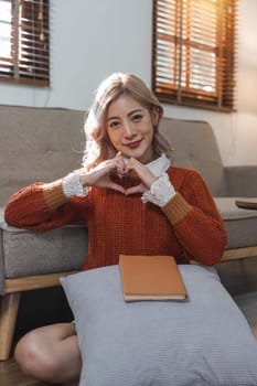 Beautiful young woman with book on pillow ready to read at home.