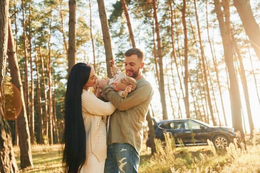 Weekend rest. Happy family of father, mother and little daughter is in the forest.