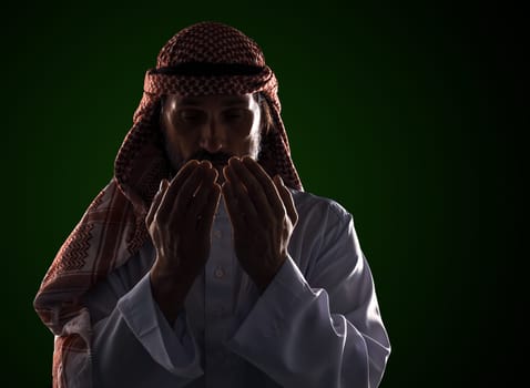 Arab man in prayer with his palms in front of his face. It conveys the devotion and spirituality inherent in Islamic culture. High quality photo