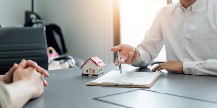 Real estate agent talked about the terms of the home purchase agreement and asked the customer to sign the documents to make the contract legally, Home sales and home insurance concept..