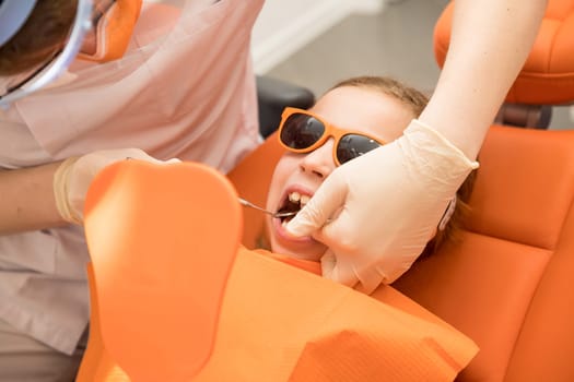 Dental plate. Expansion of the jaw in a child. teenage girl holding an orthodontic plate in her hands