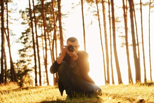 Professional photographer with camera working in the forest.