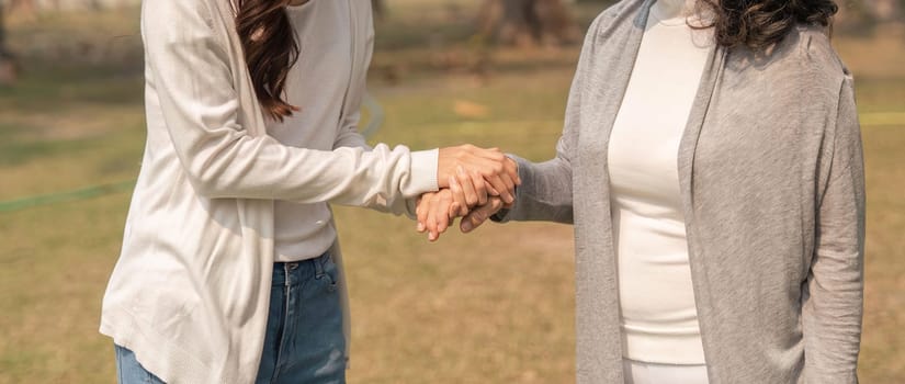 Close up of grandchildren holding her grandmother hand with love and walk together.