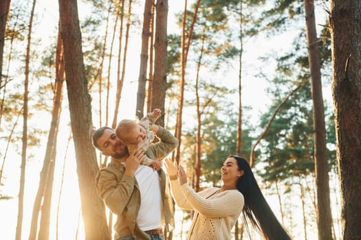 Joy and happiness. Family of father, mother and little daughter is in the forest.