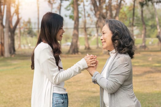 Close-up of granddaughter consoling her senior grandmother and touching hand when in park.