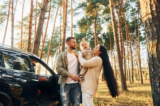 Joy and happiness. Family of father, mother and little daughter is in the forest.