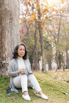 Asia grandmother 60s using tablet vacation watching Social news holiday in park.