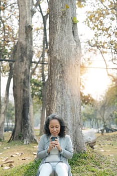 Asia grandmother 60s holiday in park and sip coffee.