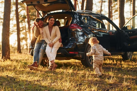 Joy and happiness. Family of father, mother and little daughter is in the forest.