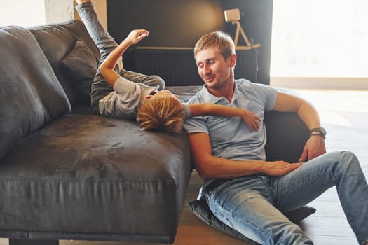 Having fun. Father and son is indoors at home together.