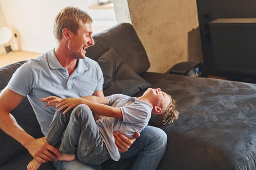 Positive emotions. Father and son is indoors at home together.