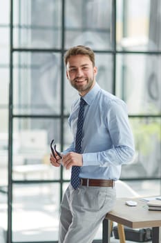 Young cheerful businessman working at office