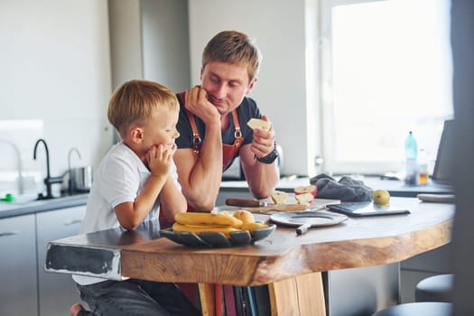 Conception of culinary. Father and son is indoors at home together.