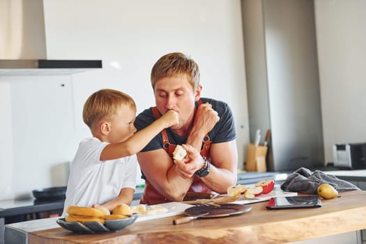 Healthy food. Father and son is indoors at home together.