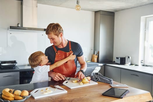 Healthy food. Father and son is indoors at home together.