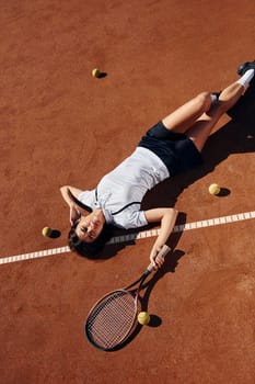 View from above. Female tennis player is on the court at daytime.