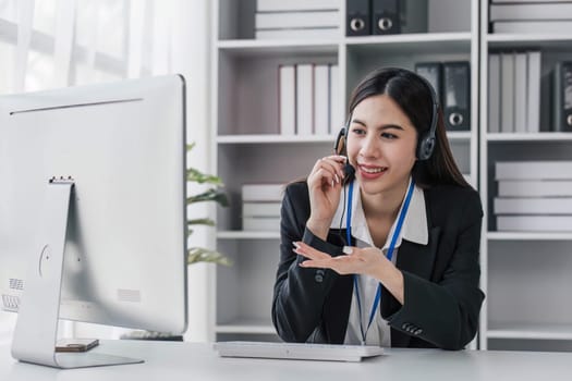 close up call center operator in wireless headset talking with customer, woman in headphones with microphone consulting client on phone in customer support service, looking at computer screen...