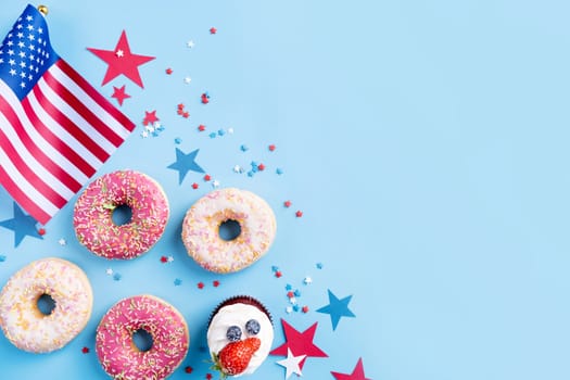 Fourth of july celebration. Sweet cupcakes and donuts with usa flag on blue background