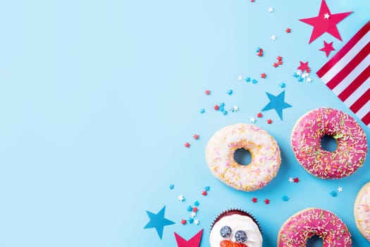 Fourth of july celebration. Sweet cupcakes and donuts with usa flag on blue background