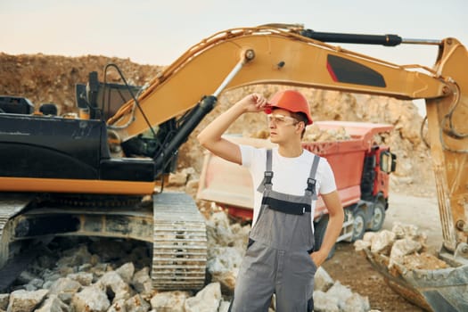 Portrait of worker in professional uniform that is on the borrow pit at daytime.