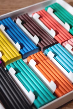 Multicolored plasticine on a wooden table close up