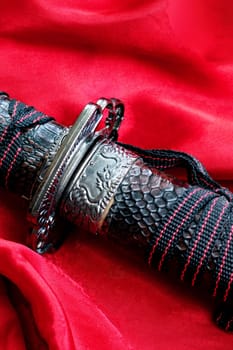 Samurai sword on the red cloth close up