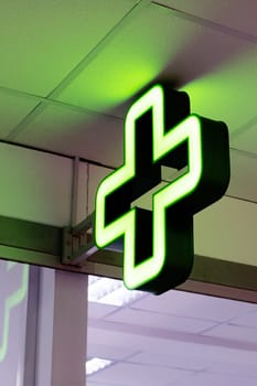 Bulb green cross indoor close up, pharmacy pointer