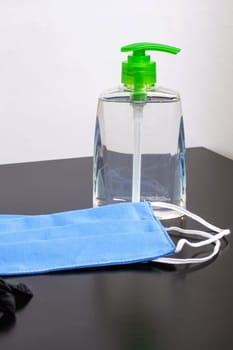 Bottle with disinfectant and medical masks on wooden the table