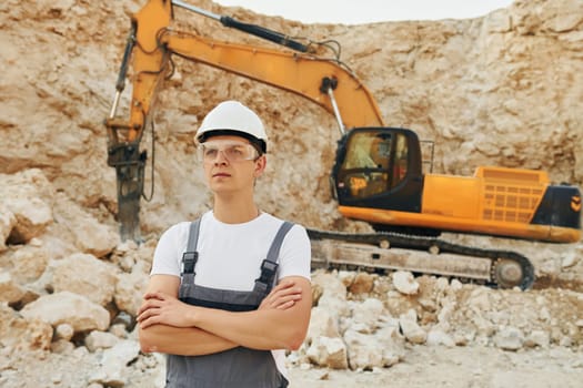 Big career. Worker in professional uniform is on the borrow pit at daytime.