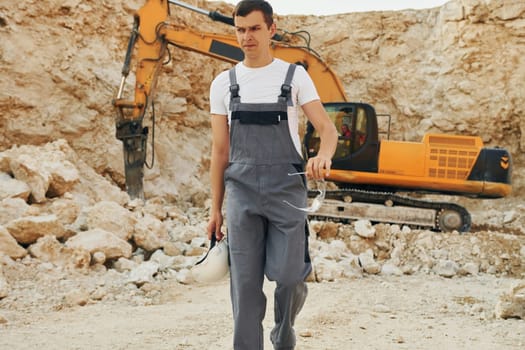 Operator is working on the borrow pit. Man in professional uniform.