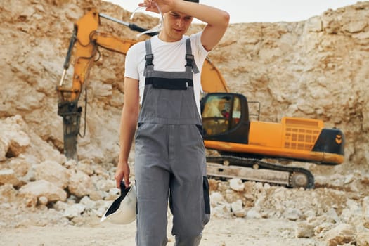 Operator is working on the borrow pit. Man in professional uniform.